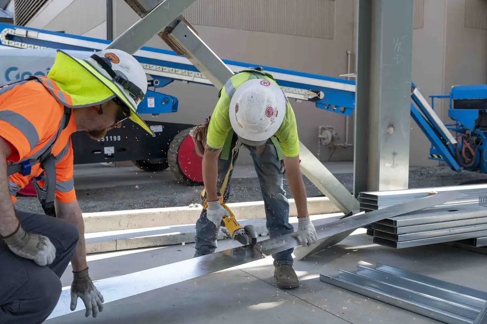 Construction worker in a fall protection harness tied off on a roof, beside a verified OSHA training certificate