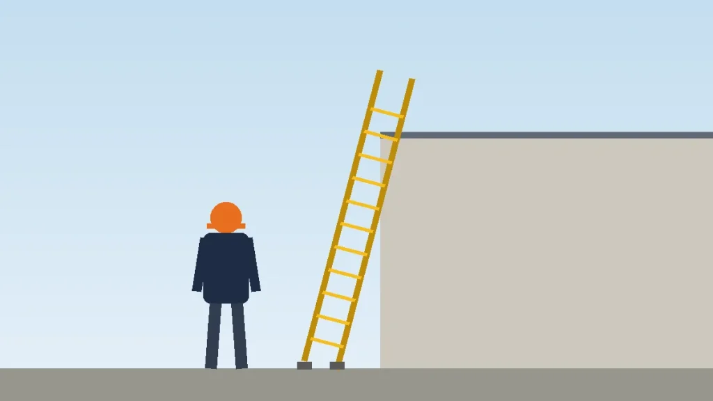 Worker standing near an extension ladder whose side rails reach above the top of a wall