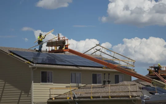 A roofer working on a house roof in a housing area